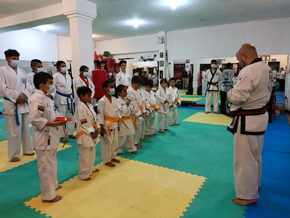 Niños alineados frente a un maestro durante una clase